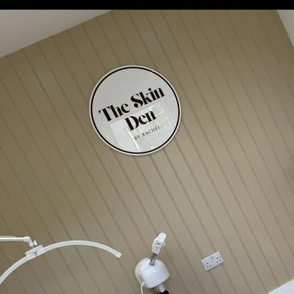 The Skin Den treatment room with circular wall logo